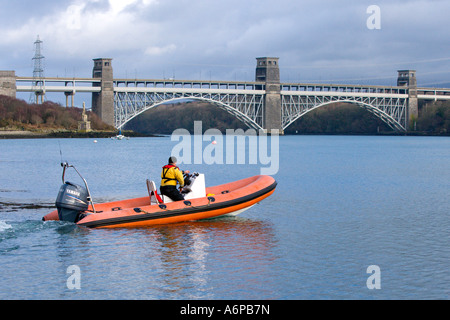 Aufblasbare macht getrieben Boot vorbei in der Nähe von Britannia Bridge auf die Menai Straits, Anglesey Stockfoto