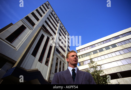Geschäftsmann stand draußen Bürogebäude in der Stadt Leeds Yorkshire uk Stockfoto