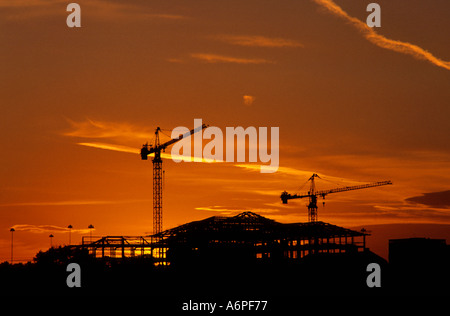 Krane auf der Baustelle in der Stadt Leeds bei Sonnenuntergang Yorkshire uk Stockfoto