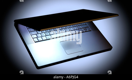 EIN LAPTOP AUF SCHWARZEM HINTERGRUND MIT WEIßEN LICHTSCHEIN Stockfoto