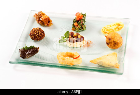 EINE AUSWAHL AN WARMEN UND KALTEN MEZE AUF EINER GLASPLATTE Stockfoto