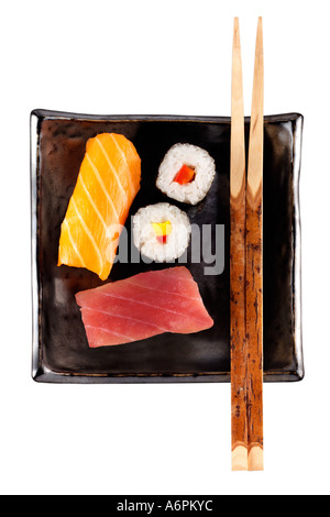 quadratische schwarze Platte mit zwei Stücken von rohem Fisch, Sushi, die weiße Tischplatte mit Stäbchen Stockfoto