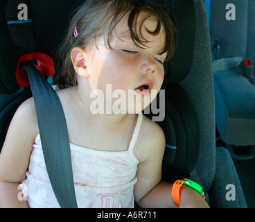 Kleinkind schläft im Autositz Stockfoto