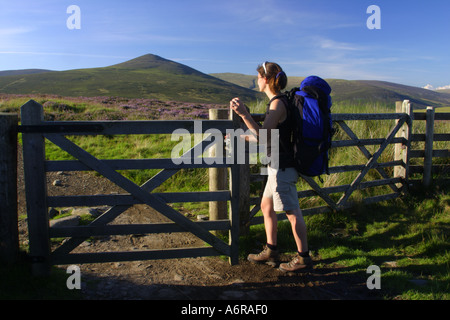 ENGLAND Cumbria Lake District National Park A weibliche Wanderer öffnet sich ein Tor auf dem richtigen Weg in der Nähe von Lonscale fiel Stockfoto