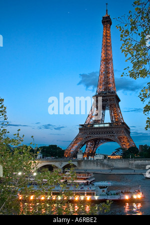 Eiffelturm Twilight touristischen Boote mit Lichtern vorbei in Seineufer im Vordergrund Paris Frankreich Stockfoto