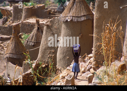 Junge mit einem Eimer auf dem Kopf in Ireli, Dogon Stamm Dorf, Mali, Afrika. (MR) Stockfoto