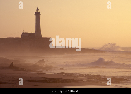 Afrika, Marokko, Rabat, Lighhouse bei Sonnenuntergang mit Wellen und Liebhaber auf Felsen Stockfoto