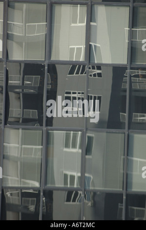 Windows spiegelt sich in langweiligen grauen Gebäude Innenstadt Stockfoto