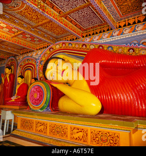 Bunt dekoriert rote und gelbe Buddha liegend mit hoch Dach über dem Kopf am Issurumuniya Tempel Sri Lanka Stockfoto