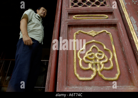 Mann steht am Eingang zu einem Pavillon in der Nähe der kaiserlichen Tresor, Himmelstempel, Peking, China. Stockfoto