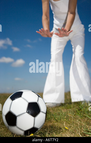 Fußball auf dem Rasen vor Frauenbeine Stockfoto