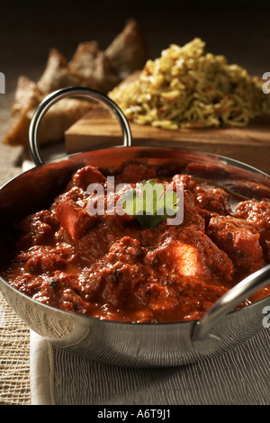Chicken Tikka Masala in Chrom Balti Gericht mit Reis und Samosa im Hintergrund Stockfoto