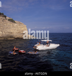 Spaß in der Sonne und die ausgelassene Stimmung im Meer mit Rib-Charter-Portale - Festrumpfschlauchboot vor Anker in einer ruhigen Bucht (Cala) in Stockfoto