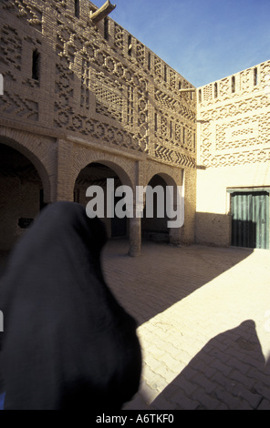 Afrika, Tunesien Tozeur Oase. Verschleierte Frau und Schlamm Ziegelbau im historischen Viertel. Stockfoto