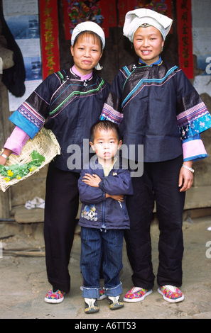 China, Yunnan, Qujing Bezirk teilnehmen. Zwei junge Bouyei Frauen, Schwestern & kleiner Junge; Lazhe Dorf Stockfoto