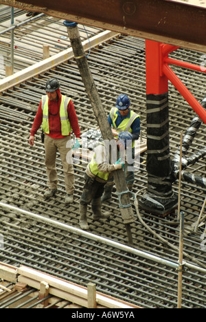 Aus der Vogelperspektive London Tiefe Fundamente für neue Büroblöcke Baufortschritte Arbeiter platzieren Beton aus Pumpenschlauch in Stahlverstärkungskäfig UK Stockfoto