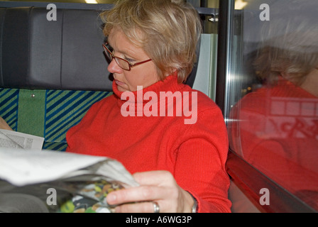 Herr Frau sitzt in einem Zug Regading Zeitung Stockfoto