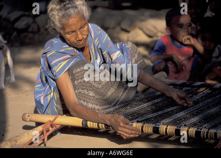 Asien, Indonesien, Flores, Nggela Dorf. Eine traditionelle Ikat Weaver und hausgemachte Webstuhl Stockfoto