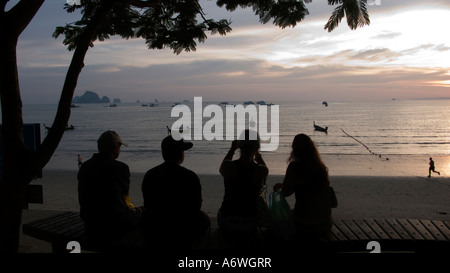 Menschen sitzen auf den Stufen zum Strand von Ao Nang in Krabi Thailand den Sonnenuntergang Stockfoto