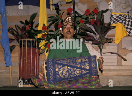 Asien, Indonesien, Bali. Mann in traditioneller Kleidung spielen Trommel während der Zeremonie Stockfoto