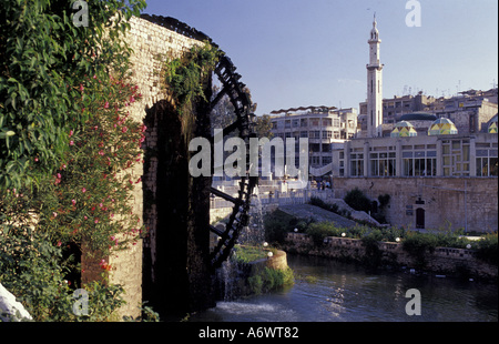 Syrien, Hama, hölzerne Wasserrad und die Moschee al-Nuri am Fluss Orontes. Stockfoto