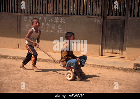 Thailand, KMT Dorf. KMT Hill Tribe jungen mit selbst gebastelten Spielsachen vor Schulhaus. (MR) Stockfoto