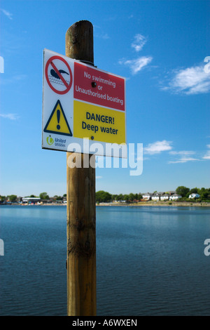 Melden Sie auf einem Pfosten eines Sees, Gefahr des Tiefenwassers angibt, und Schwimmen Einschränkungen vor. Stockfoto