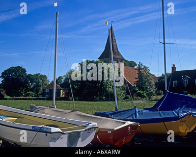BOSHAM WEST SUSSEX UK Juni Blick über den Dorfanger in Richtung der Holy Trinity Church mit gestrandeten Boote im Vordergrund Stockfoto