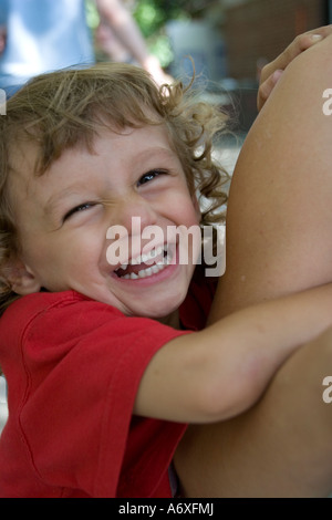 Zwei Jahre alte Gefühl sehr sicher festhalten an seiner Mutter s Arm New York City Herr lächelnd Stockfoto