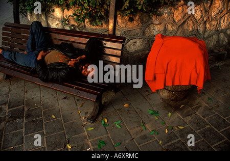 Ein Obdachloser schläft auf einer Bank Innenstadt von Tel Aviv Israel Stockfoto