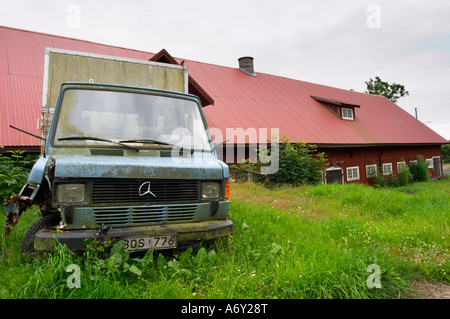 Eine rostige alte Mercedes Lkw LKW in einem Feld. Traditionelles schwedisches Holzhaus bemalte. Scheune Smaland Region. Schweden, Europa. Stockfoto