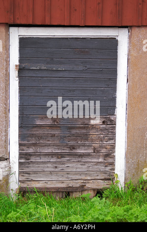 Traditionelles schwedisches Holzhaus bemalte. Schwarze Tür. Peeling-Malerei zu verblassen. Smaland Region. Schweden, Europa. Stockfoto