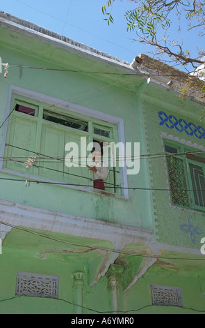 Ein kleiner Junge am Fenster seines Hauses im Dorf von Pushkar, Indien Stockfoto