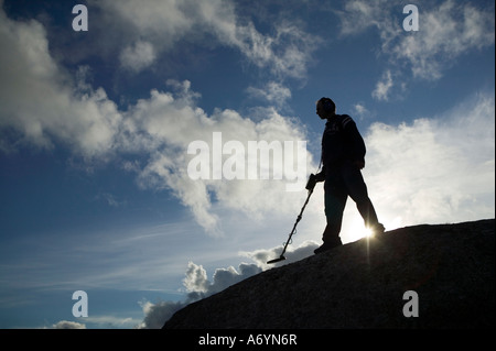 Mann mit Metalldetektor Silhouette gegen trübe & blauen Himmel. Stockfoto