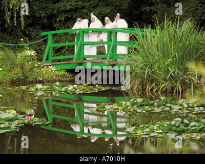 Vier Nonnen auf der japanische Brücke im Garten des impressionistischen Malers Claude Monet Giverny Eure Normandie Fran Stockfoto