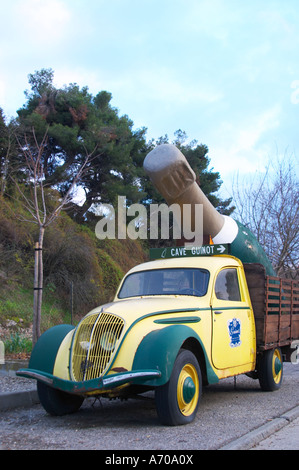 Guinot Höhle. Gelb und grün Oldtimer Peugeot 202 mit einer gigantischen Limoux Flasche dient als eine Werbung Werbung für das Weingut. Limoux. Languedoc. Frankreich. Europa. Stockfoto