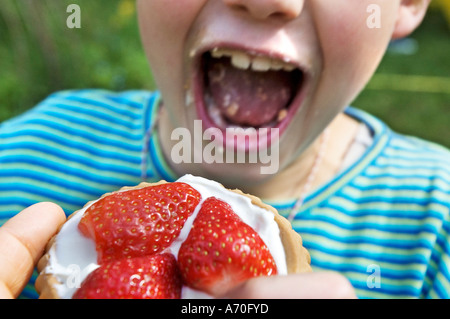 Kind essen Erdbeer Törtchen Stockfoto