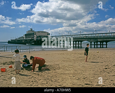 BOURNEMOUTH DORSET UK April Blick auf den Pier mit Jugendlichen spielen am Strand Stockfoto