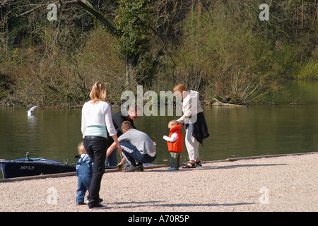 Kleinkinder, die Rettungsweste tragen, werden an Bord des Ruderboots auf dem Bootssee in Sussex unterstützt. Swanbourne Lake, Arundel, West Sussex, England Stockfoto