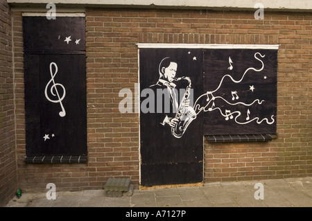 Werbung für eine Jazzbar in Volendam North Holland mit einem Wandbild eines Saxophonisten und musikalischen Noten auf einer Backsteinwand. Stockfoto