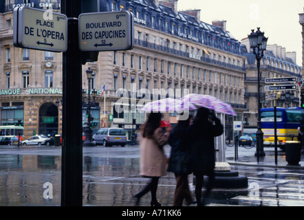 Paris mit Blick aus einem Fenster auf den Boulevard des Capucines und die Kreuzung Place de L'Opera an einem regnerischen Tag. Rechte Bank. Architektur des 19. Jahrhunderts. Stockfoto