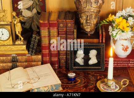 Büchereien und Blumen auf einem Tisch. Private Wohnung persönliche Andenken Antiquitäten auf einem Tisch. Erinnerungen. Wohneinrichtungen Stockfoto