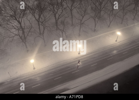 Mann über die Straße laufen, springen über die Pfütze im Winter Schneesturm, Chicago USA Stockfoto