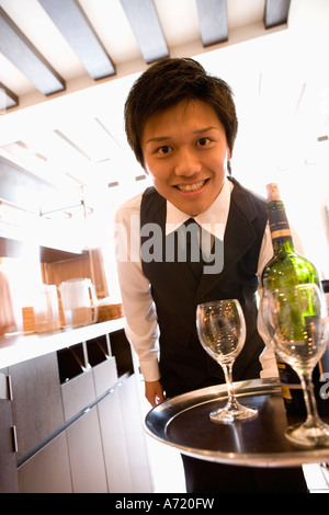 Kellner tragen Flasche Wein und Gläser auf Tablett Stockfoto
