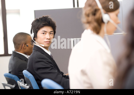 Junger Mann im Call-center Stockfoto