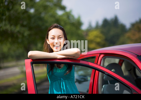 Junge Frau, die offene Tür des Auto gelehnt Stockfoto