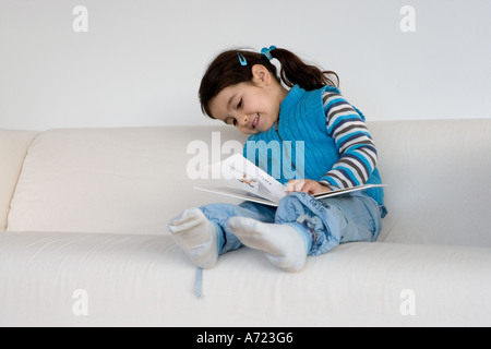 Kleines Mädchen, die vorgibt, ein Buch zu lesen Stockfoto