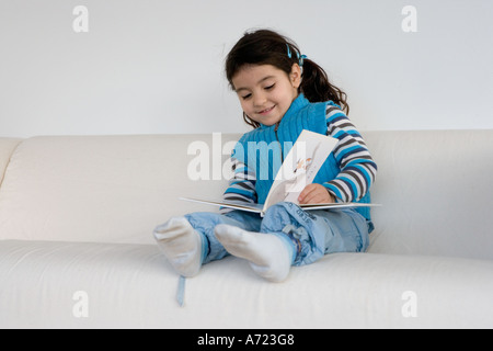 Kleines Mädchen, die vorgibt, ein Buch zu lesen Stockfoto