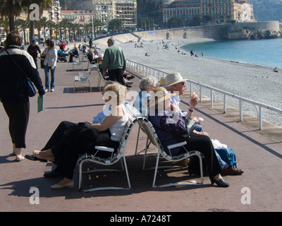 Ältere Menschen genießen die Sonne auf der Promenade des Anglais in Nizza, Frankreich, im zeitigen Frühjahr - Côte d ' Azur Stockfoto