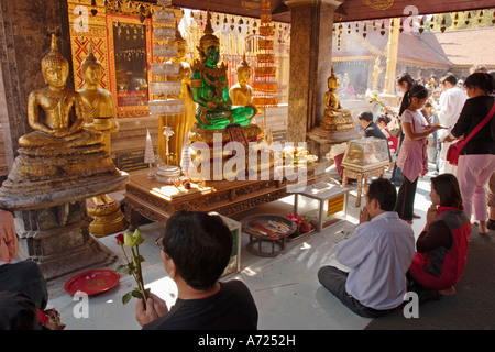 Die Menschen beten am Altar mit Smaragd-Buddha-Bild im Wat Phrathat Doi Suthep, einem hoch verehrten buddhistischen Tempel in Chiang Mai, Thailand. Stockfoto